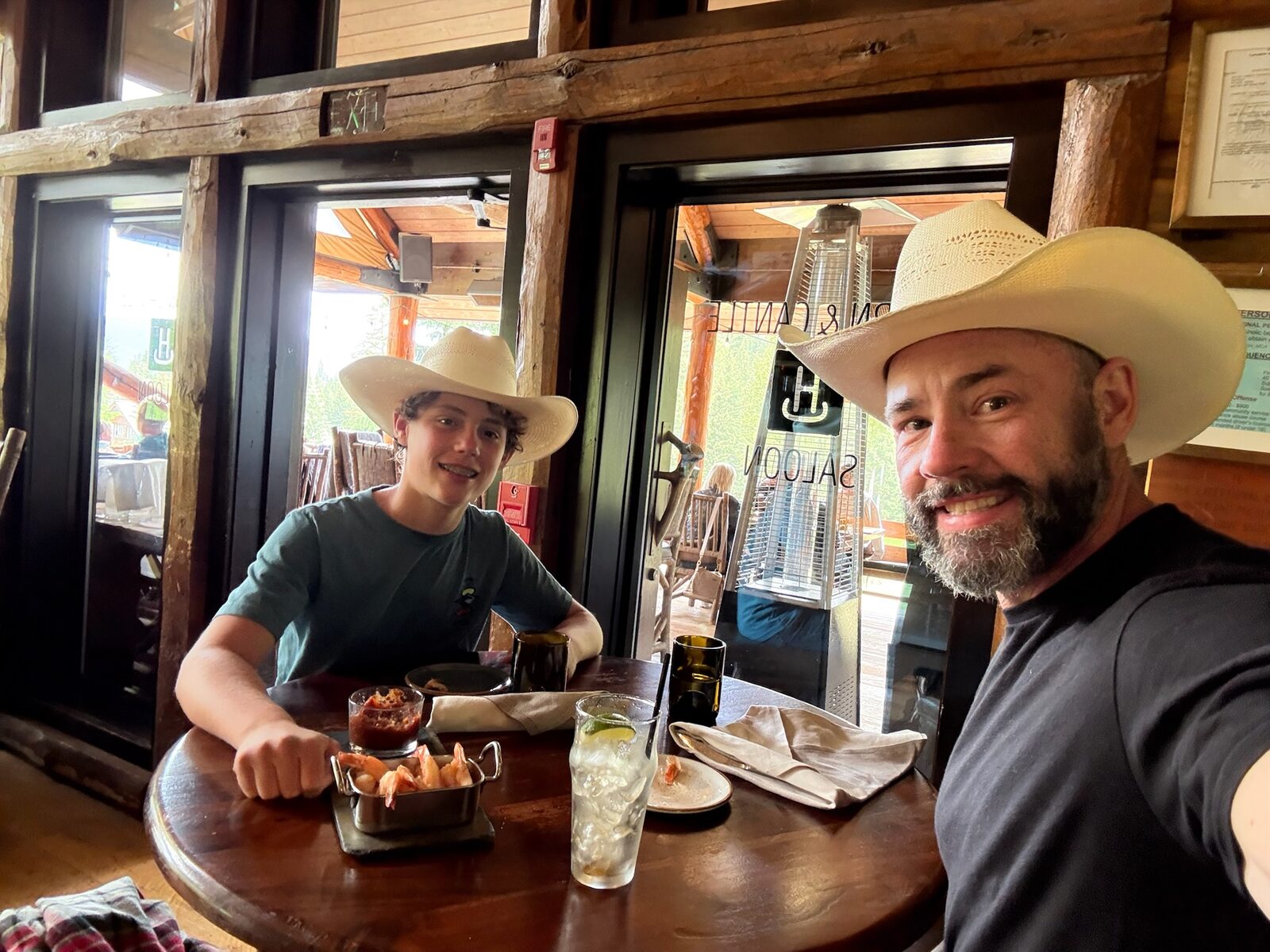 Mark and Dylan at a saloon table back at the ranch