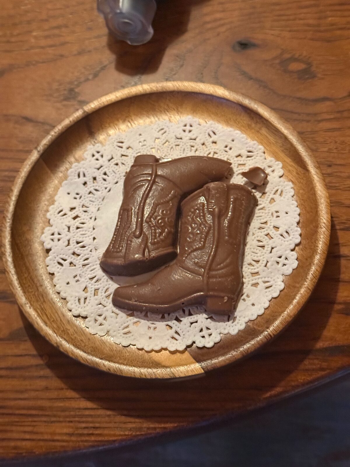 A pair of chocolate cowboy boots on a doily