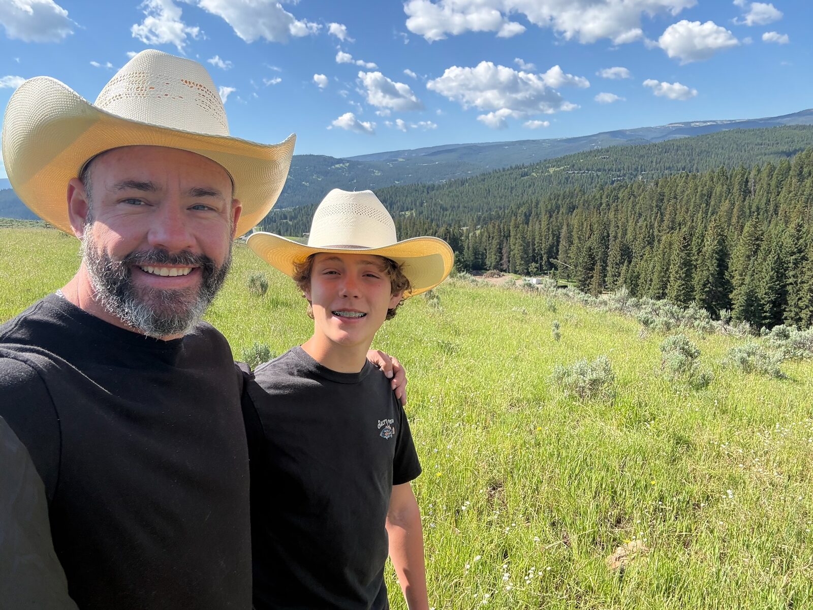 Mark and Dylan selfie on a hillside above the ranch